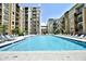 Resort style pool surrounded by lounge chairs, landscaped greenery and elegant building architecture at 711 Cosmopolitan Ne Dr # 123, Atlanta, GA 30324