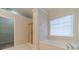 Bright bathroom featuring a soaking tub, separate shower, and a window that offers natural light at 1022 Pecan Grove Pl, Lawrenceville, GA 30046