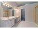Bathroom featuring double vanity, large mirror, and glass-enclosed shower; walk-in closet located nearby at 1022 Pecan Grove Pl, Lawrenceville, GA 30046