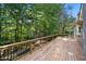 Wooden deck with black metal railing overlooks a private, wooded backyard at 1585 Lazy River Ln, Sandy Springs, GA 30350