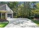 Wide concrete driveway leading to attached garage with ample parking space and mature trees at 1585 Lazy River Ln, Sandy Springs, GA 30350