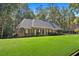 Beautiful single story brick home with lush green lawn and mature trees at 1585 Lazy River Ln, Sandy Springs, GA 30350