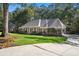 Beautiful single story brick home with lush green lawn, mature trees, long driveway and side entry garage at 1585 Lazy River Ln, Sandy Springs, GA 30350