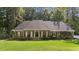 Charming brick home with an arched entryway and well-manicured lawn and landscaping at 1585 Lazy River Ln, Sandy Springs, GA 30350