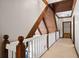 Upstairs hallway featuring wood beams and railing overlooking the living room at 1585 Lazy River Ln, Sandy Springs, GA 30350
