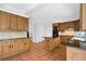 Open kitchen featuring wood cabinets, dark granite countertops, and terra cotta floor at 1585 Lazy River Ln, Sandy Springs, GA 30350
