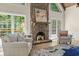 Cozy living room showcasing a stone fireplace, natural light, and comfortable seating at 1585 Lazy River Ln, Sandy Springs, GA 30350