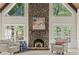 Bright living room featuring a stone fireplace, large windows with wooded views, and stylish decor at 1585 Lazy River Ln, Sandy Springs, GA 30350