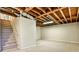 Unfinished basement area with exposed ceiling beams and carpeted floors leading to stairs at 1598 Kings Rd, Marietta, GA 30062