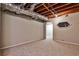 Carpeted basement with exposed ceiling and ductwork leading to a connected room at 1598 Kings Rd, Marietta, GA 30062
