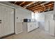 Basement kitchen area with white cabinets, a microwave, and a full-sized refrigerator at 1598 Kings Rd, Marietta, GA 30062