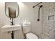 Modern bathroom featuring a white sink and tile with speckled shower and sleek black fixtures at 1598 Kings Rd, Marietta, GA 30062