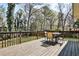 Outdoor deck with patio table and chairs overlooking a green, tree-lined yard at 1598 Kings Rd, Marietta, GA 30062