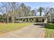 Charming home with a well-manicured front lawn and a long driveway leading to the property at 1598 Kings Rd, Marietta, GA 30062
