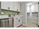 Kitchen with stainless steel dishwasher, white cabinets, and next to pantry and laundry at 1598 Kings Rd, Marietta, GA 30062