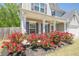 Two-story home featuring a covered porch with blooming roses and a well-maintained lawn at 207 Cherokee Reserve Cir, Canton, GA 30115