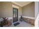 Covered front porch and entrance featuring stone accents and decorative potted plants at 207 Cherokee Reserve Cir, Canton, GA 30115