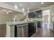 Gourmet kitchen with granite island, stainless steel appliances, dark cabinetry, and an open view of the staircase at 207 Cherokee Reserve Cir, Canton, GA 30115