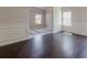 Spacious living area with neutral walls, crown molding, and hardwood floors, flowing into the dining area at 207 Cherokee Reserve Cir, Canton, GA 30115
