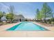 Community pool with lounge chairs, a bath house, and a blue sky at 207 Cherokee Reserve Cir, Canton, GA 30115
