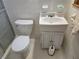 Small bathroom with white tiled walls, a toilet, and a sink with cabinet at 2555 Angus Sw Ct, Marietta, GA 30008