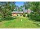 Traditional home showcasing a stone chimney and inviting front yard surrounded by lush trees at 3955 Old Fairburn Sw Rd, Atlanta, GA 30331