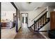 Inviting foyer featuring stone flooring, carpeted stairs, and decorative wall art at 3955 Old Fairburn Sw Rd, Atlanta, GA 30331