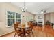 Charming dining area with a round table, chandelier, hardwood floors, and natural light at 4560 Weathervane Dr, Alpharetta, GA 30022