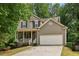 Two-story home with neutral siding, a covered porch, and attached two-car garage at 4560 Weathervane Dr, Alpharetta, GA 30022