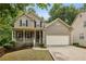 Charming two-story home with a welcoming front porch, a two-car garage, and a well-manicured lawn at 4560 Weathervane Dr, Alpharetta, GA 30022