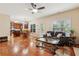 Open living room with hardwood floors, ceiling fan, and an open floor plan to the kitchen at 4560 Weathervane Dr, Alpharetta, GA 30022