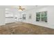 Living room with windows and view into kitchen with white cabinetry and breakfast bar at 4560 Weathervane Dr, Alpharetta, GA 30022