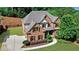 Charming brick home featuring a well-manicured lawn, mature trees, and a long driveway at 1168 Woodtrace Ln, Auburn, GA 30011