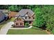 Charming brick home featuring a well-manicured lawn, mature trees, and a long driveway at 1168 Woodtrace Ln, Auburn, GA 30011