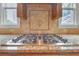 Modern stainless steel gas cooktop with granite countertops and tiled backsplash at 1168 Woodtrace Ln, Auburn, GA 30011