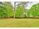 Expansive backyard with lush green grass and mature trees at 1719 Kings Cross Ct, Hoschton, GA 30548