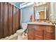 Bathroom featuring wooden cabinets, decorative mirror, and shower with a curtain at 1719 Kings Cross Ct, Hoschton, GA 30548