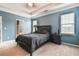 Primary bedroom featuring a king bed, two windows, blue walls, and attached bathroom at 1719 Kings Cross Ct, Hoschton, GA 30548