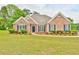 Charming brick home with well-manicured lawn and lush landscaping at 1719 Kings Cross Ct, Hoschton, GA 30548