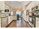 Modern kitchen with stainless steel appliances, open to the dining and living areas at 1719 Kings Cross Ct, Hoschton, GA 30548