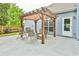 Cozy outdoor seating area under a wooden pergola on a concrete patio at 1719 Kings Cross Ct, Hoschton, GA 30548