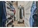 Walk-in closet with hanging clothes and white wire shelving on both sides at 1719 Kings Cross Ct, Hoschton, GA 30548