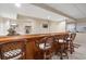 Basement wet bar boasts wooden countertop, shelving, barstools, and neutral paint at 400 Fieldstone Lndg, Alpharetta, GA 30005