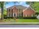 Charming brick house with dark green shutters and a green lawn on a sunny day at 400 Fieldstone Lndg, Alpharetta, GA 30005