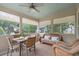 Cozy screened porch with wicker seating, ceiling fan, and dining table, offering a tranquil outdoor space at 400 Fieldstone Lndg, Alpharetta, GA 30005