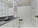 Bathroom featuring floral wallpaper, with a shower and tub, and a vanity with a black countertop at 4274 Revere Cir, Marietta, GA 30062