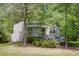 Two-story home with gray siding surrounded by lush greenery in a wooded area at 4274 Revere Cir, Marietta, GA 30062