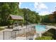 A community pool surrounded by lush greenery and featuring a covered picnic area for relaxing and enjoying the outdoors at 4274 Revere Cir, Marietta, GA 30062