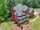 Aerial view of the home showing the roof, landscaping, and a curved driveway approaching a luxury brick home at 6615 Callanwalde Ct, Suwanee, GA 30024