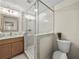Bathroom showcasing a glass-enclosed shower, wood vanity, and a modern mirror at 6615 Callanwalde Ct, Suwanee, GA 30024